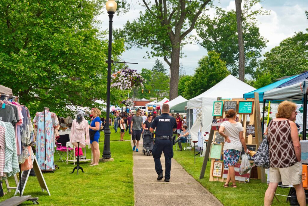 Outdoor market with people and vendor tents.
