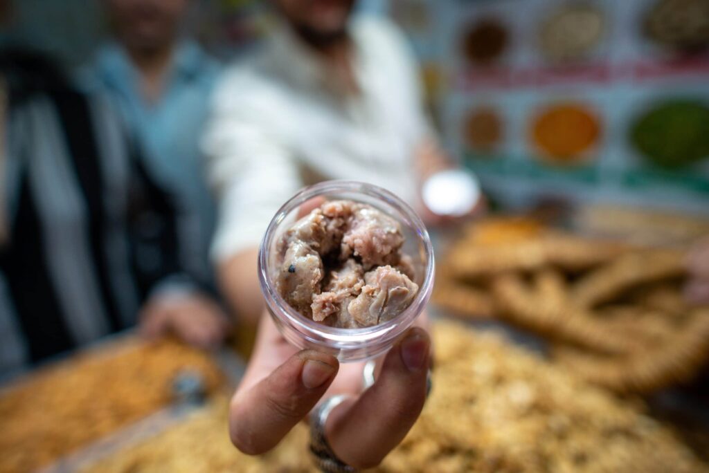 Person holding small container of meat.