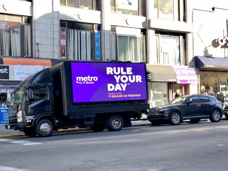 LED billboard truck for Metro by T-Mobile displaying "RULE YOUR DAY" advertisement in Manhattan, New York City, promoting prepaid services.