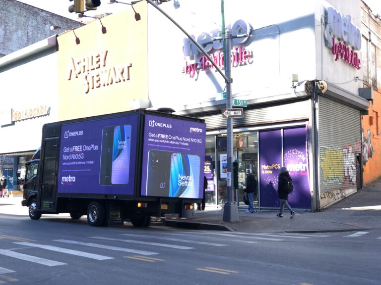 LED billboard truck advertising OnePlus Nord N10 5G promotion parked outside a Metro by T-Mobile store in New York City, showcasing guerrilla marketing strategy.