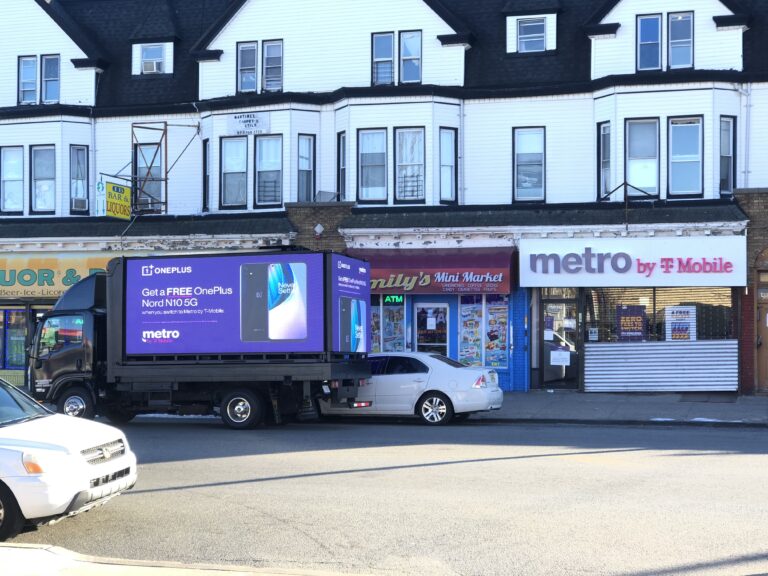 LED billboard truck promoting OnePlus Nord N10 5G parked outside a Metro by T-Mobile store in New York City, showcasing guerrilla marketing strategy for consumer engagement.