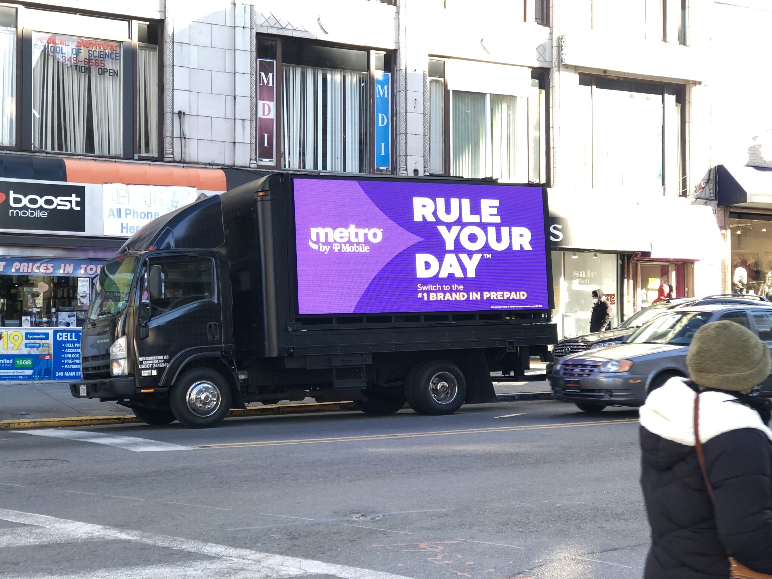 LED billboard truck advertising Metro by T-Mobile in Manhattan, featuring "RULE YOUR DAY" slogan and promoting prepaid services.