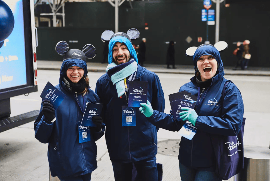 Three people in Disney-themed winter clothing.
