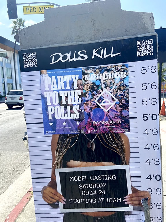 Model casting poster on city street wall.