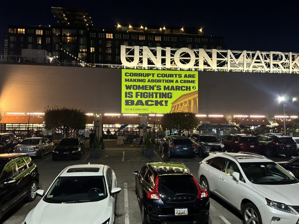 Union Market with protest sign at night.