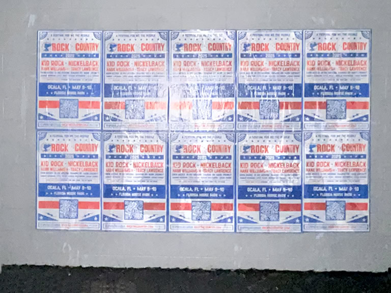 Concert posters on a wall, nighttime view.