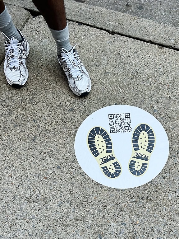 Person standing near QR code sticker on ground.