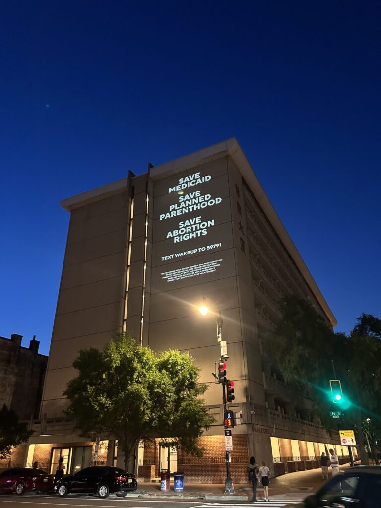 Building with projected pro-choice messages at night.