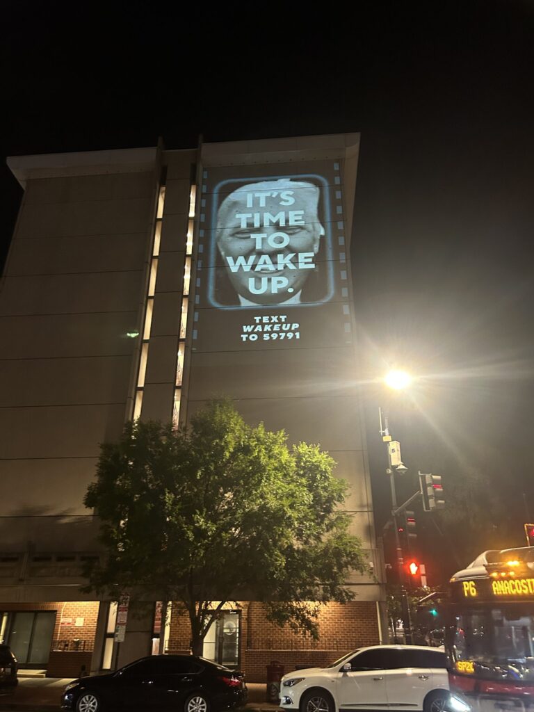 Building with "It's Time to Wake Up" projection.