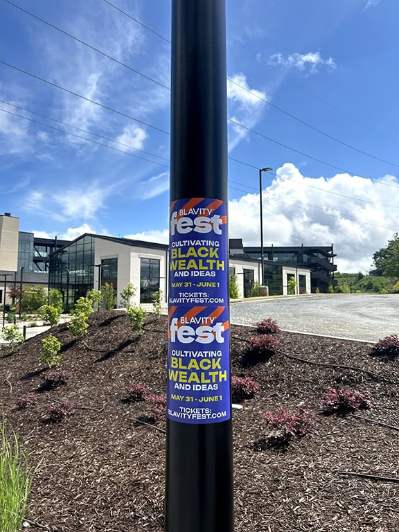 Sign on pole promoting Blavity Fest event.