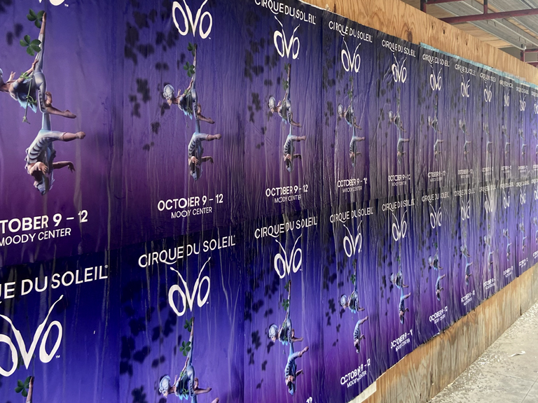 Wild wheat paste posting advertising featuring multiple posters for Cirque du Soleil's "Ovo," showcasing acrobats and event details, prominently displayed in an urban setting in Illinois.