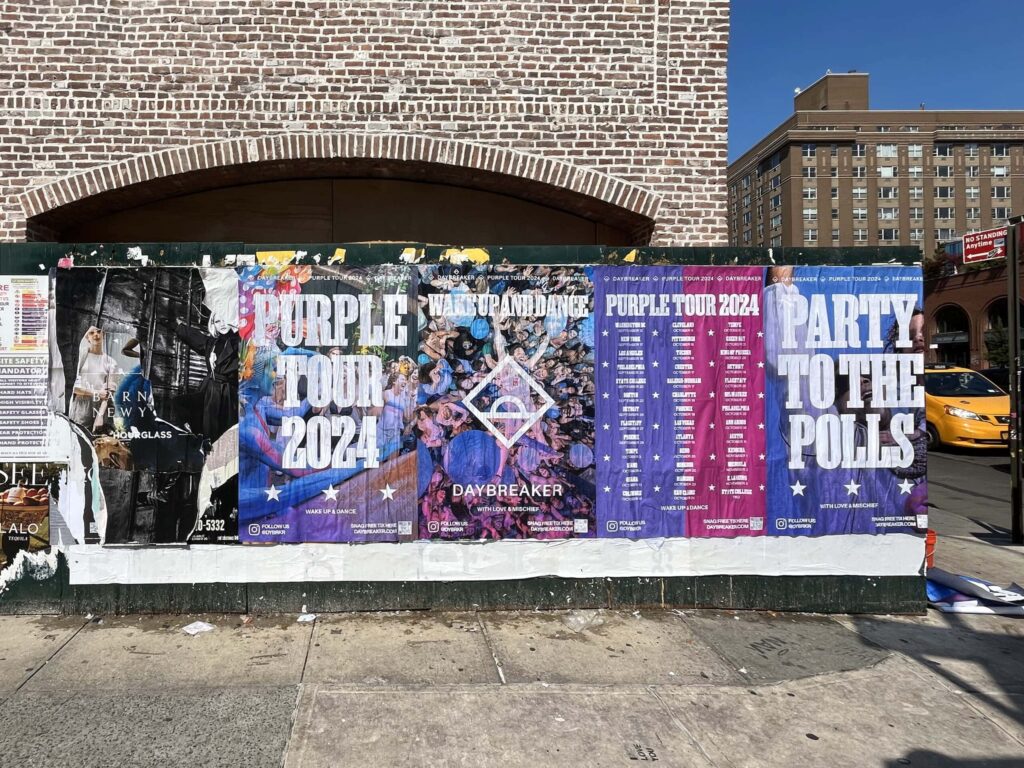 Posters on brick wall in urban area.