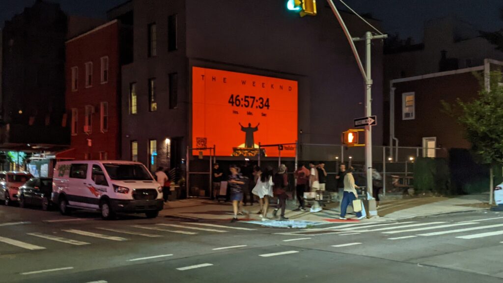 Street scene with illuminated countdown billboard.