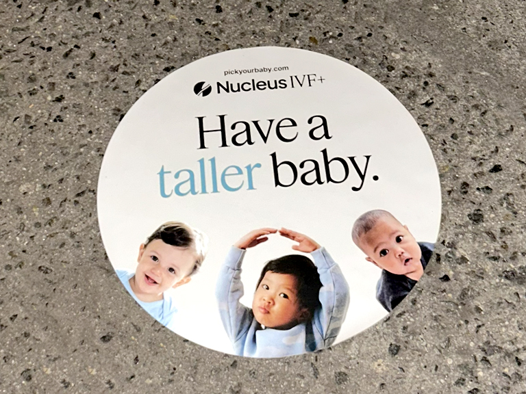 Sidewalk stencil advertisement featuring three babies and the text "Have a taller baby." with Nucleus IVF+ branding.
