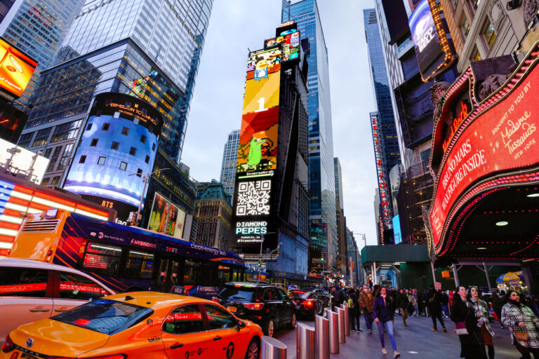 Times Square billboard featuring Diamond Peeps campaign, vibrant colors, animated graphics, and QR code, surrounded by bustling pedestrians and yellow taxis during peak foot traffic.