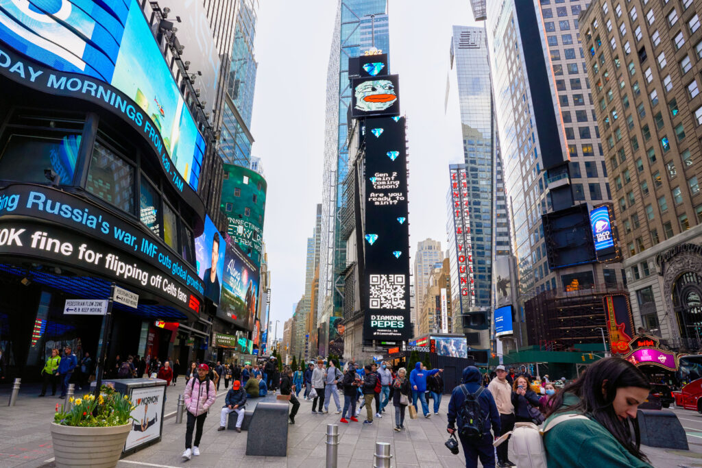 Times Square billboard advertising Diamond Peeps, featuring vibrant digital graphics and a QR code, with a bustling crowd of pedestrians in Manhattan, NY.