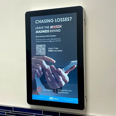 Digital advertising display featuring a promotional message for Gamban, encouraging users to quit online gambling, with a QR code for a free trial.