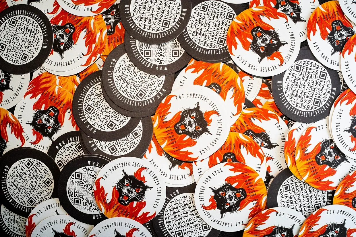 Colorful promotional stickers featuring a black panther logo surrounded by flames and QR codes, illustrating guerrilla marketing tactics for data collection and proximity marketing.