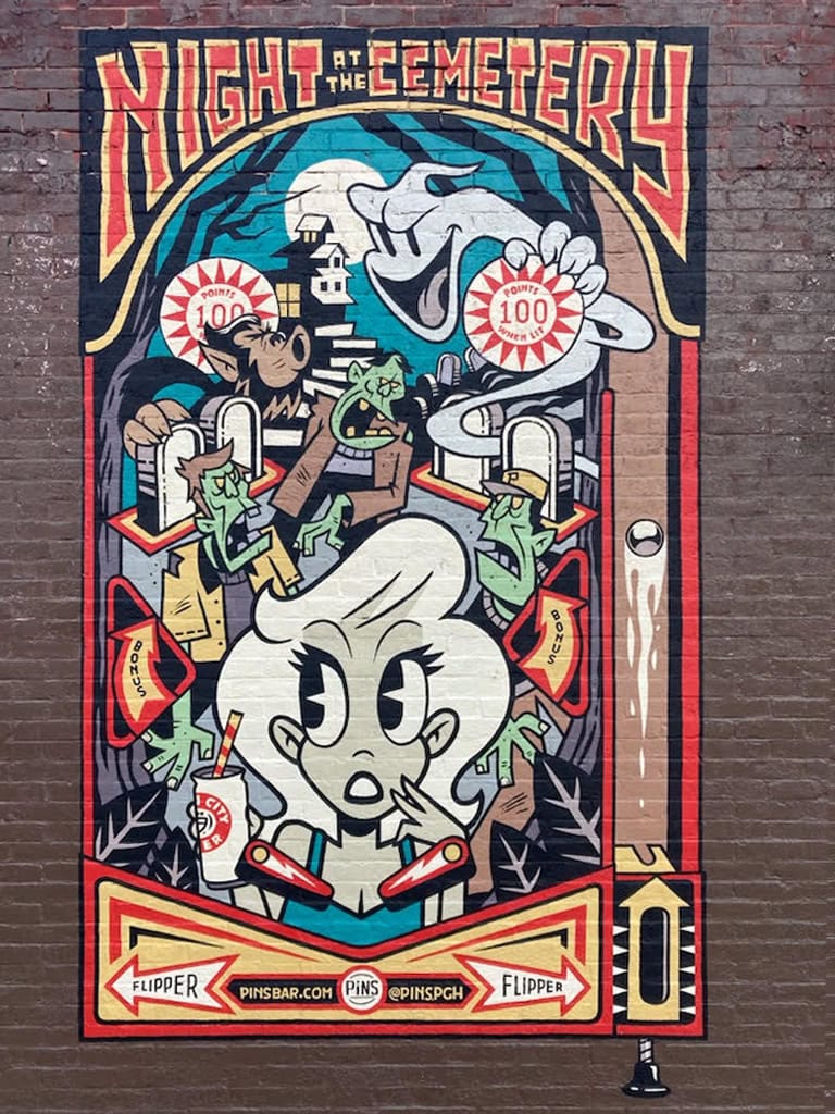 Pinball-themed mural with cartoon characters.