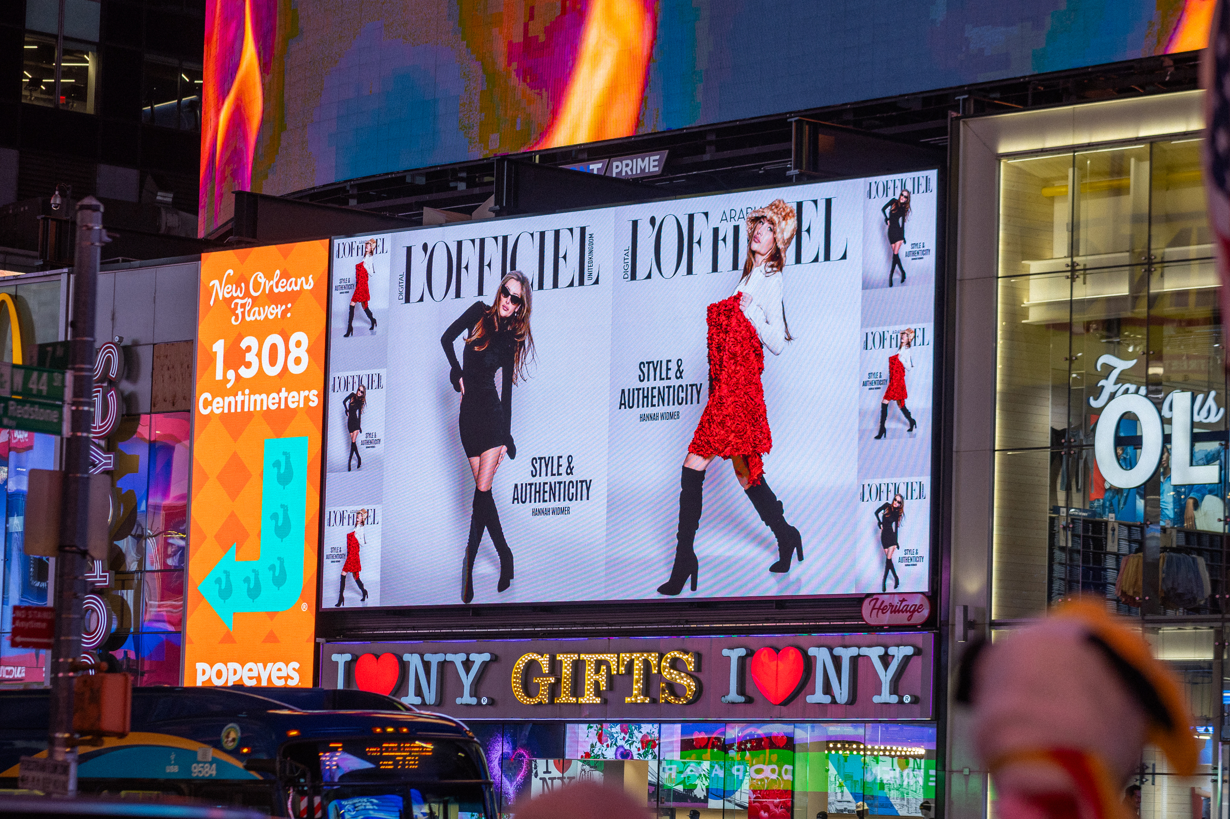Times Square digital billboard displaying L&rsquo;Officiel fashion editorial featuring models in stylish outfits with the tagline "STYLE & AUTHENTICITY."