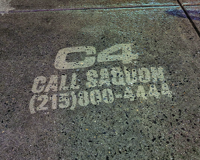 C4 Energy sidewalk stencil advertising featuring "Call Saquon" and contact number (215) 800-5444, part of guerrilla marketing campaign.