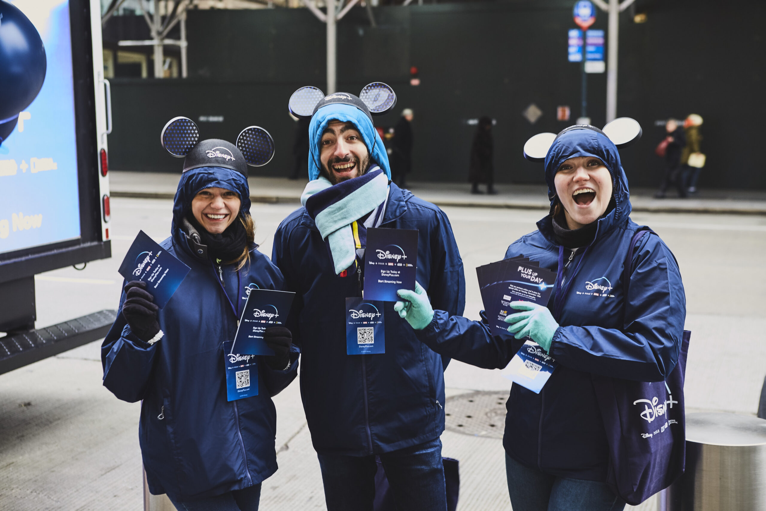 Brand ambassadors in Disney attire holding promotional materials, smiling and engaging with passersby in Manhattan, New York, showcasing brand activation efforts.