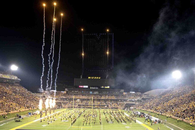 Drone light show above stadium forming "MIZZOU" with fireworks and Marching Mizzou performing on the field during halftime of the football game.