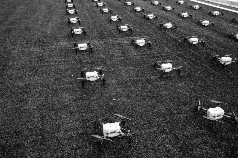 Aerial view of 300 drones arranged on the ground, preparing for a coordinated drone show at the University of Missouri's football stadium, illustrating the innovative marketing strategy by American Guerrilla Marketing.