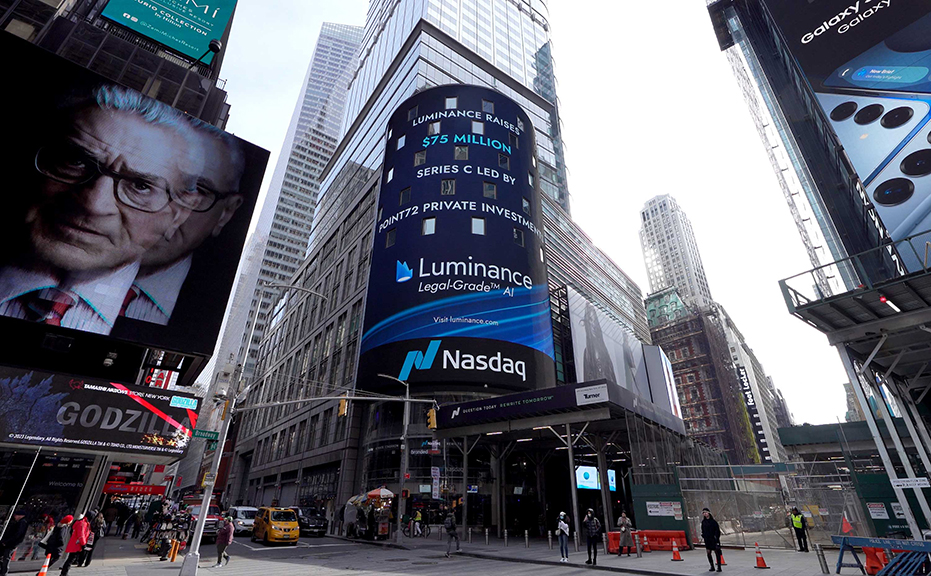 Billboard advertising in Times Square featuring Luminance's $75 million funding announcement, with Nasdaq logo and surrounding urban setting.