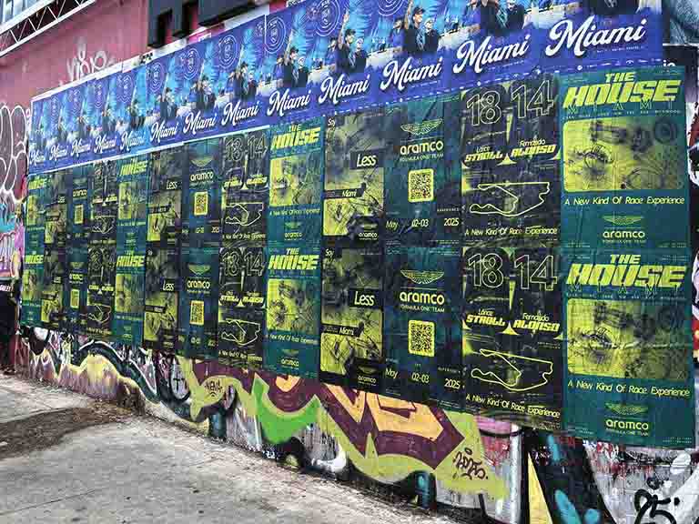 Miami-themed wild posting featuring Aston Martin "The House" promotional materials, showcasing event details and QR codes against a vibrant graffiti backdrop.