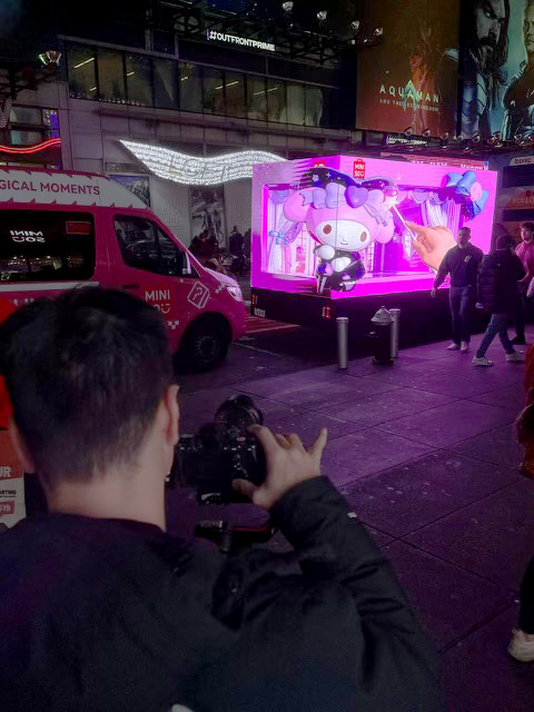 Photographer capturing 3D LED billboard truck activation featuring colorful display with animated characters in Times Square, New York, highlighting innovative advertising for MINISO and Disney collaboration.