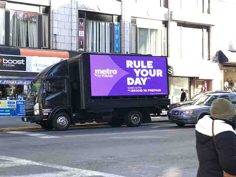 18ft LED billboard truck displaying "Rule Your Day" advertisement for Metro by T-Mobile in Manhattan, New York, showcasing mobile advertising effectiveness.