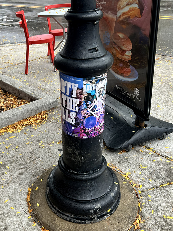 Poster for "Party to the Polls" DJ campaign by Daybreaker on a street pole in New York City, featuring vibrant graphics and event details.