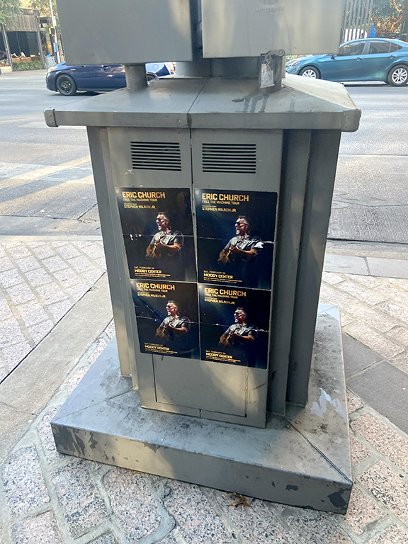 Eric Church concert posters displayed on a utility box in Austin, Texas, promoting the Moody Center performance.