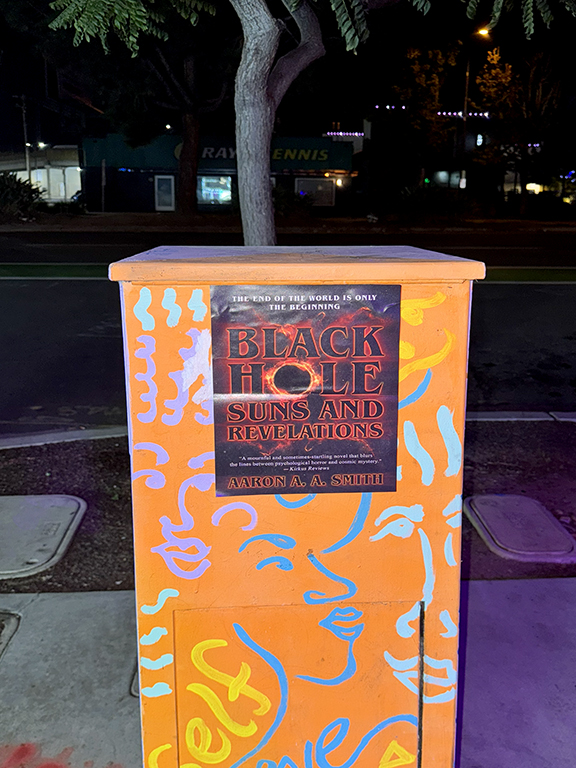 Black Hole Suns and Revelations promotional poster on an orange utility box, featuring vibrant graffiti and street visibility, linked to Snipe Posting Activation in San Diego, California.