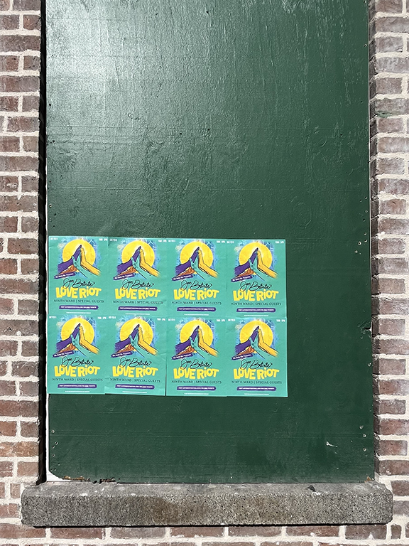 Posters promoting the "Love Riot Tour" concert, featuring colorful graphics and event details, displayed on a green wall.