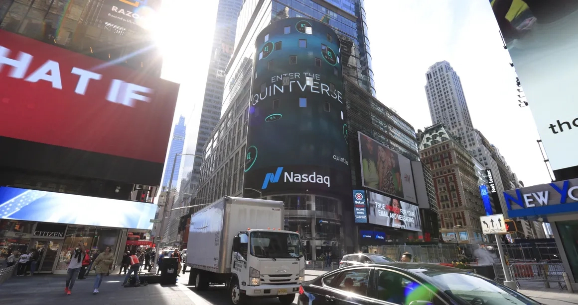 Times Square digital billboard featuring Nasdaq advertisement, bustling city scene with vehicles and pedestrians, showcasing high-traffic advertising opportunities.