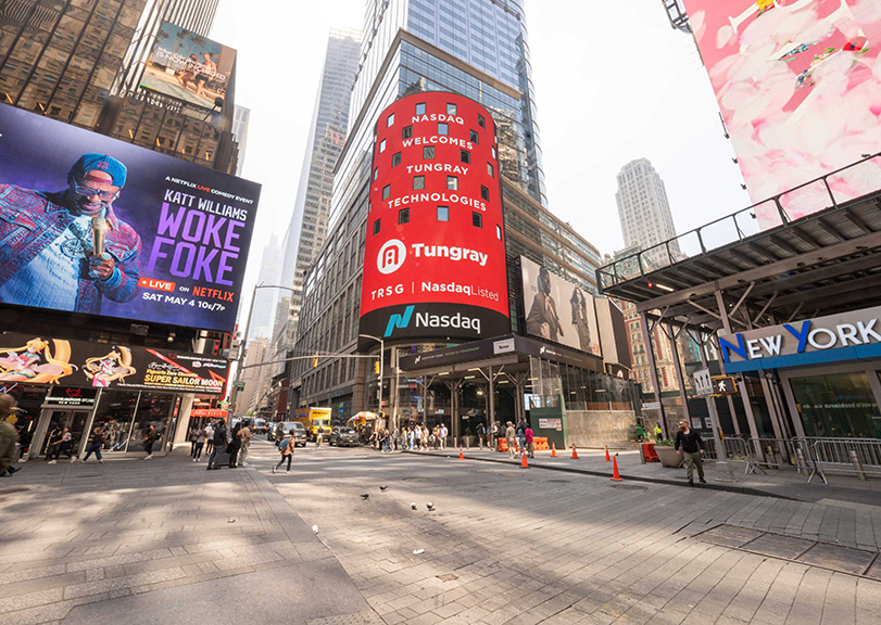 Times Square billboard featuring Nasdaq and Tungray advertisements, bustling urban setting with pedestrians and vehicles, showcasing high-impact brand visibility and advertising strategies.