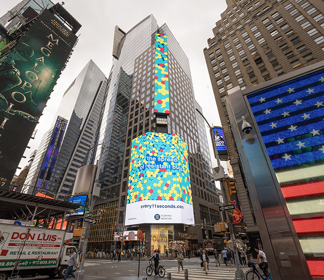 Billboard advertising campaign for The Fleming Initiative on Midtown Financial Billboard in Times Square, featuring colorful graphics and text about antimicrobial resistance.