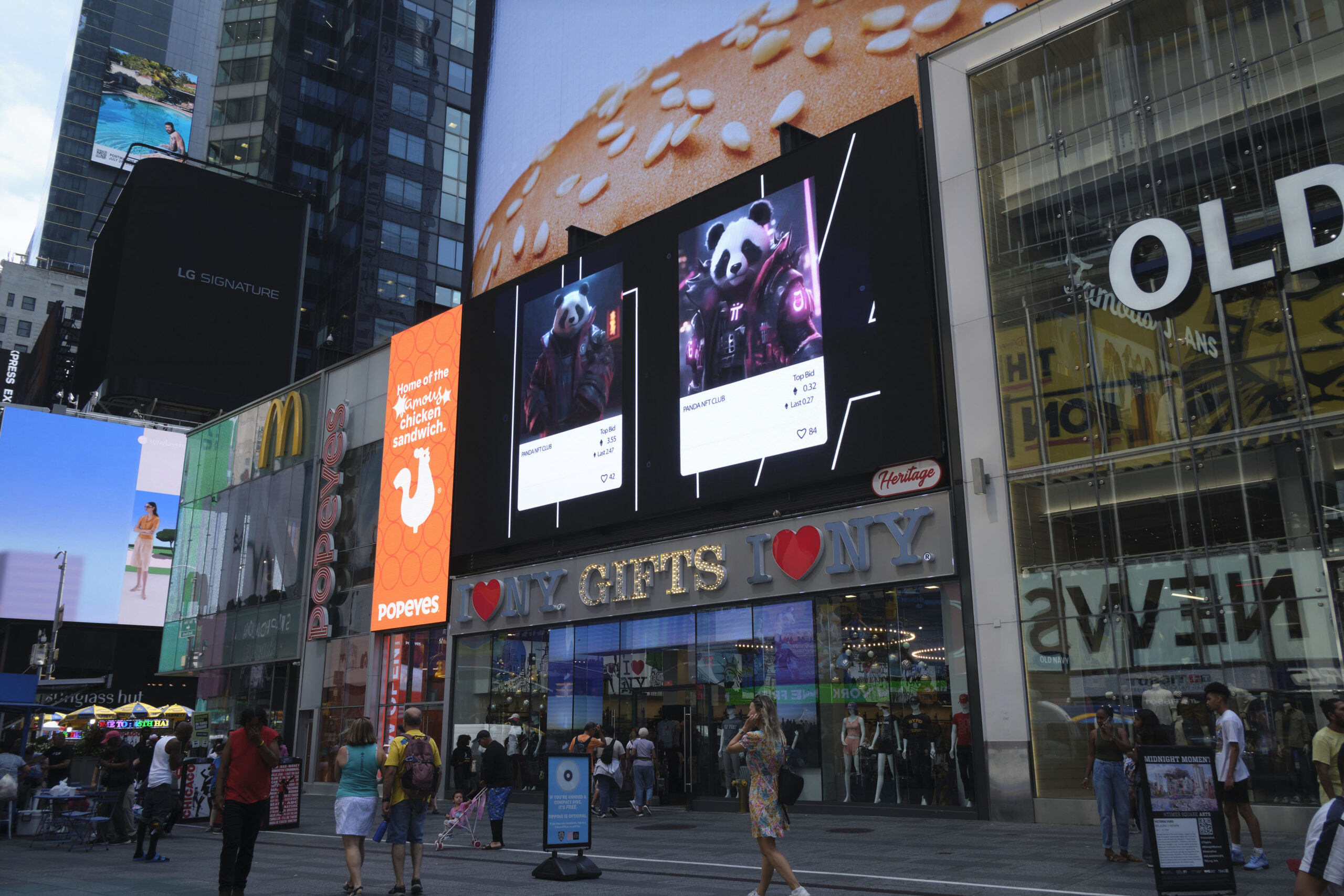 Panda NFT campaign display on large digital billboards in Times Square, featuring panda characters and promotional details, with surrounding storefronts and crowds in New York City.