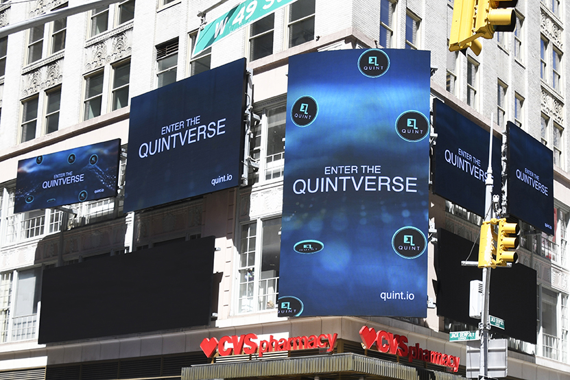 Billboards displaying "ENTER THE QUINTVERSE" and the logo of quint.io on the Brill Building in Times Square, New York City, highlighting strategic advertising placement by American Guerrilla Marketing.