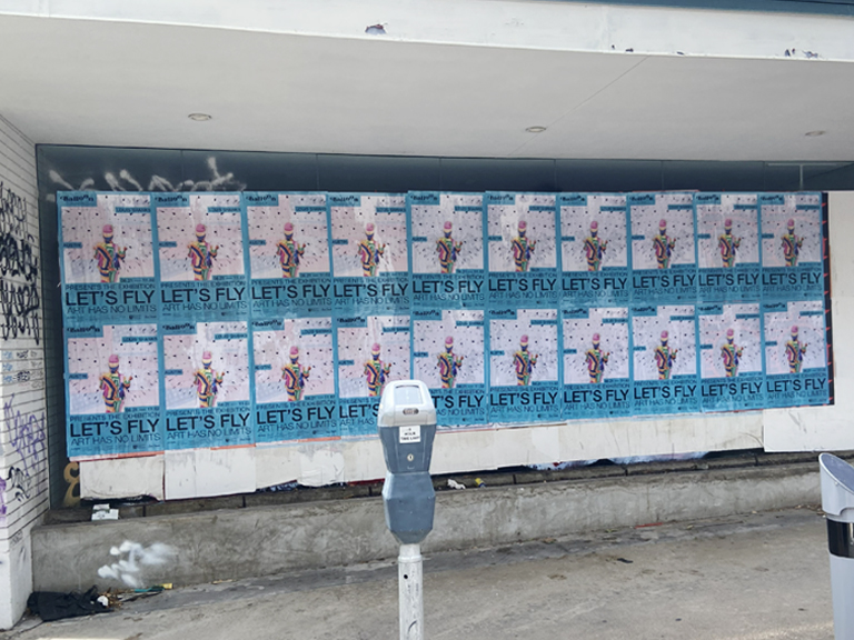 Wall covered with wheatpaste posters advertising "LET'S FLY" for the BLOON Museum, featuring colorful graphics and event details in an urban setting, showcasing guerrilla marketing techniques.