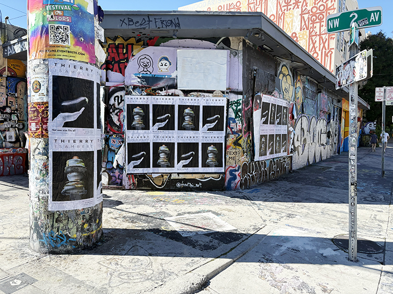 Wheatpaste advertising posters for Thierry Isambert Culinary & Event Design displayed on a graffiti-covered wall in Wynwood, Miami, showcasing urban guerrilla marketing strategy.
