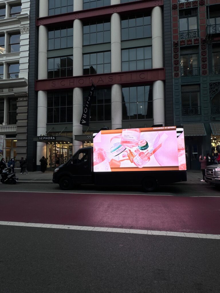 3D LED billboard truck displaying Biossance skincare products outside Sephora in New York City, showcasing vibrant animations and attracting pedestrian attention.