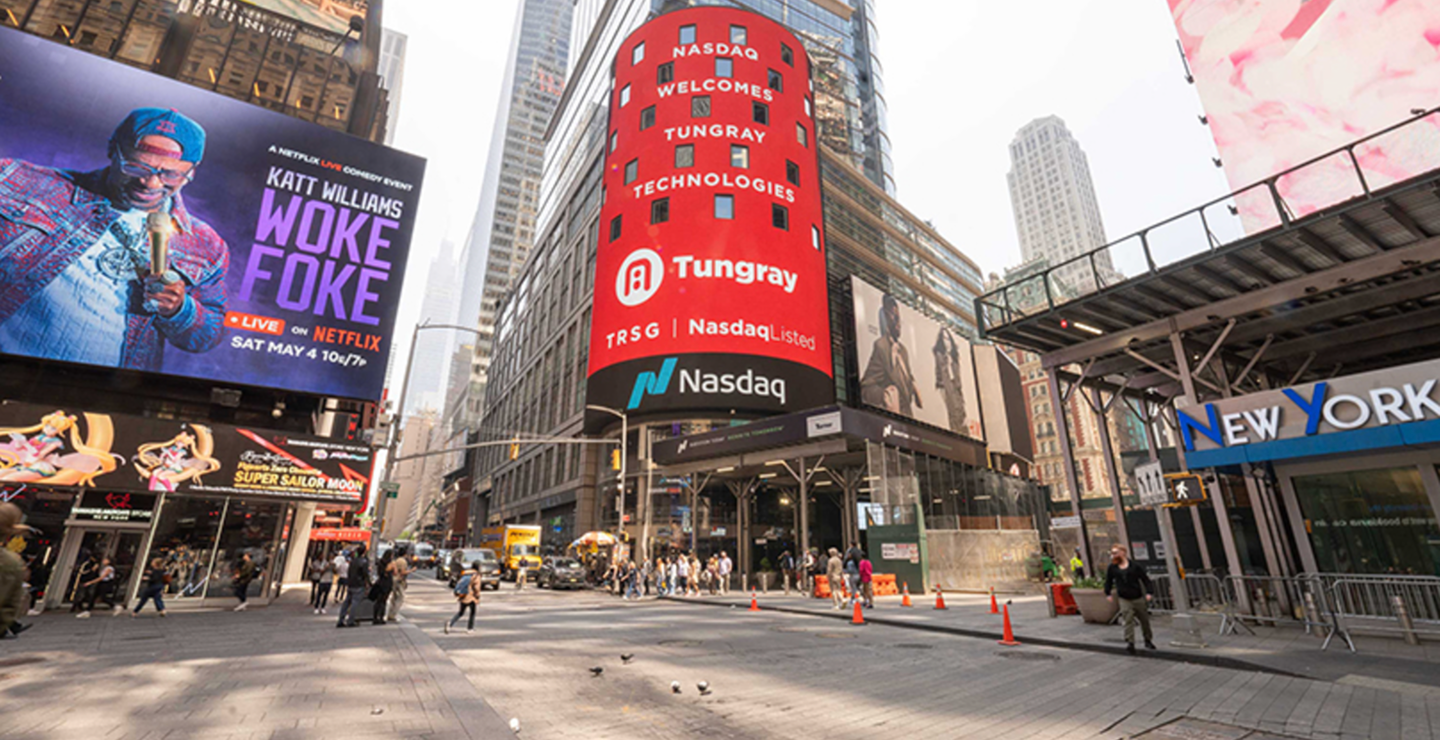 Busy Times Square scene featuring large digital billboards for Nasdaq and Tungray Technologies, with pedestrians and vehicles, emphasizing corporate brand visibility and engagement in a bustling urban environment.