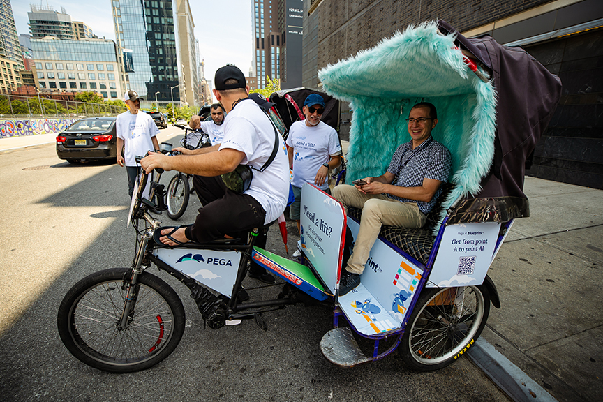 Pedicab advertising in urban setting with a cyclist and passengers, featuring promotional wraps and engaging branding for American Guerrilla Marketing.