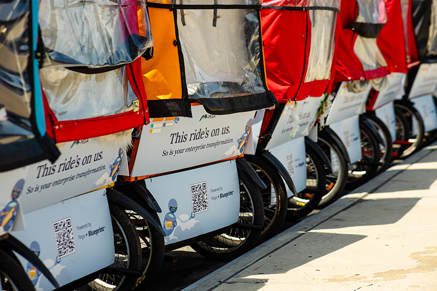Row of colorful pedicabs with advertising banners showcasing promotional messages, emphasizing free rides and enterprise transformation, relevant to pedicab advertising services by American Guerrilla Marketing.