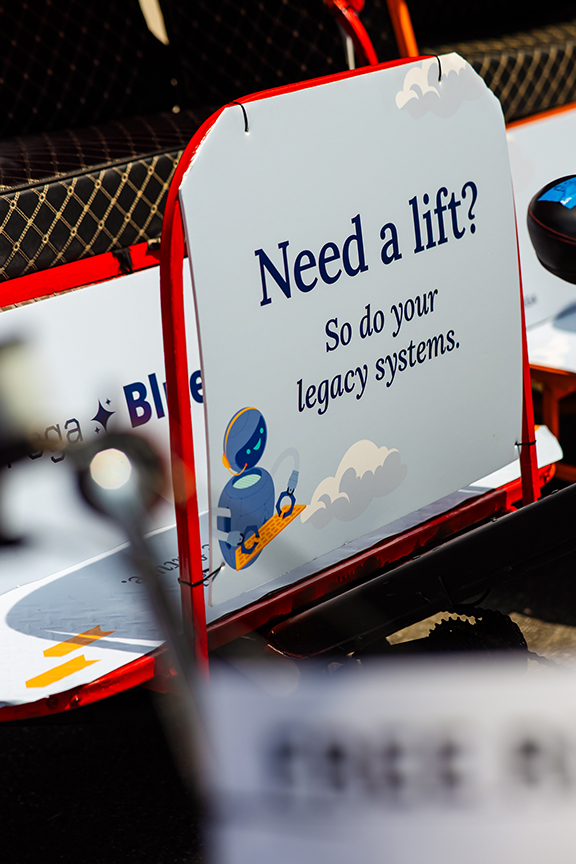 Pedicab advertisement featuring a sign that reads "Need a lift? So do your legacy systems." with a cartoon robot illustration, promoting innovative marketing solutions by American Guerrilla Marketing.