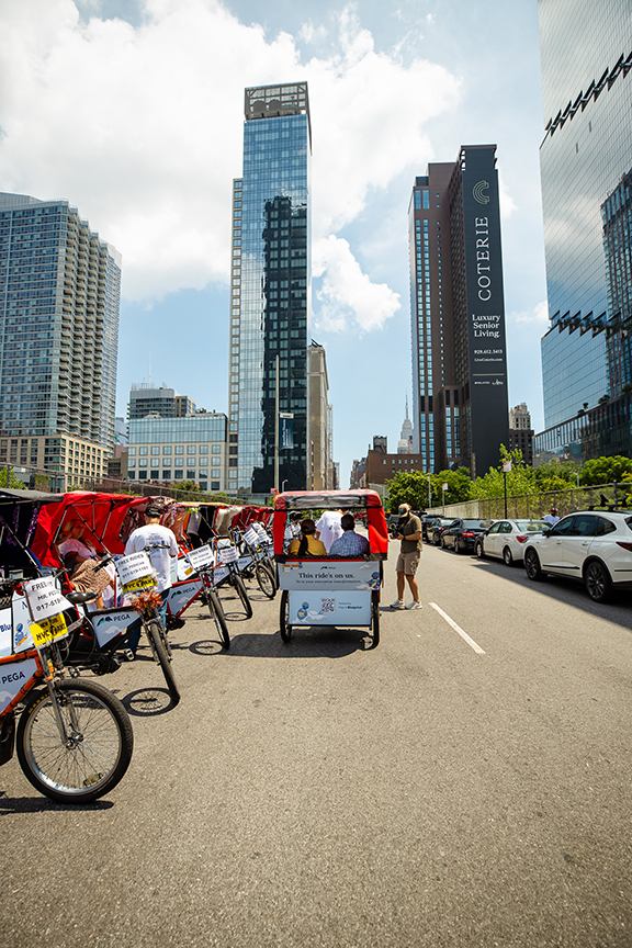 Pedicabs lined up on an urban street, showcasing vibrant advertising potential for American Guerrilla Marketing in a bustling city environment.