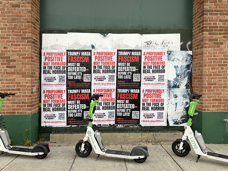 Political wild posting installation featuring bold anti-fascism messaging, prominently displayed on an urban wall with electric scooters in the foreground, targeting pedestrian engagement.